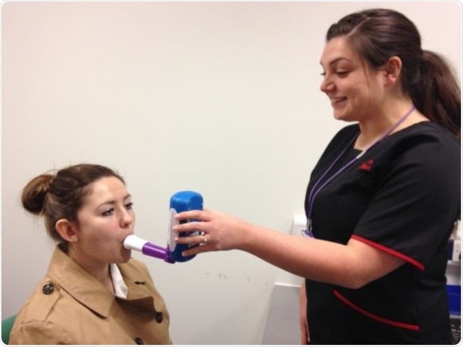 A respiratory physiologist demonstrating the NObreath® FeNO monitor with a student.