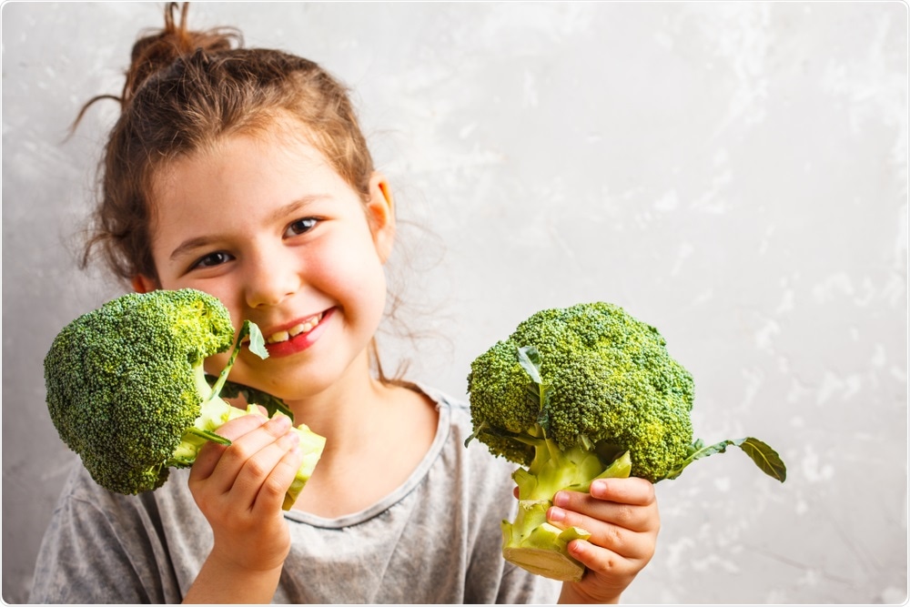 Child happy with broccoli in hands