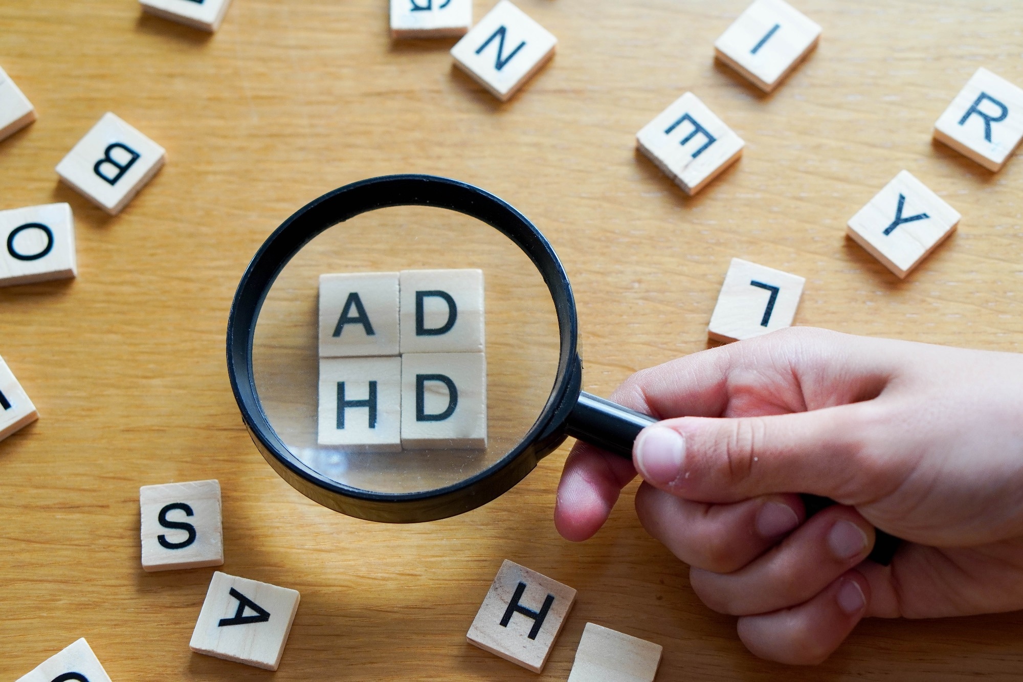 magnifying glass with wooden letters ADHD.