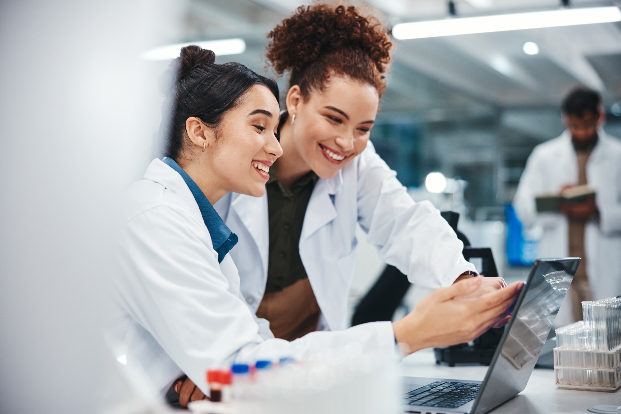 Laptop, scientist and women with smile, medical research and excited for results of test and pointing.