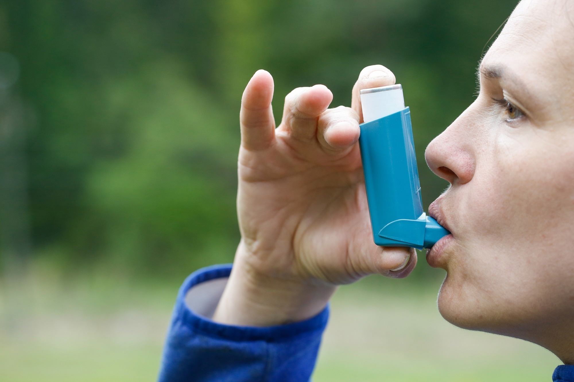 Asthma patient inhaling medication for treating shortness of breath and wheezing