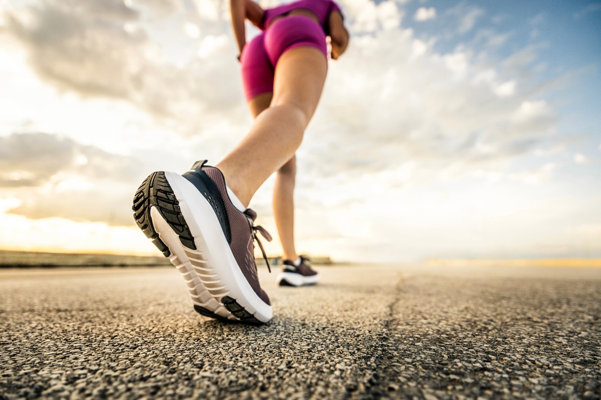 Runner woman feet running on urban road