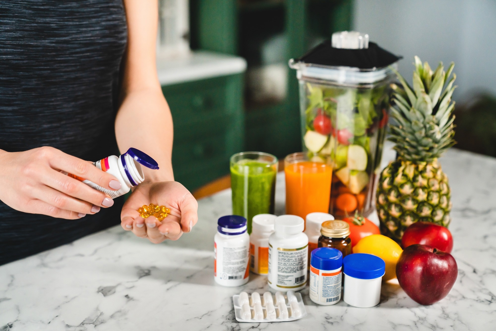 Woman taking various food supplements and fruit smoothie