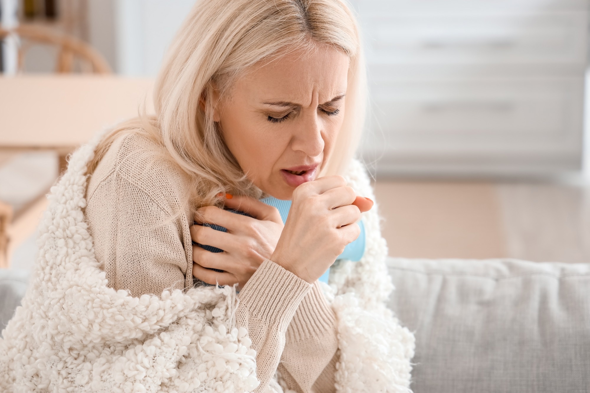 Ill mature woman coughing at home, closeup