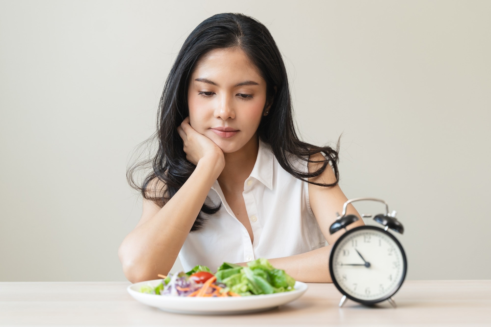 Woman looking at meal waiting time to eat during intermittent fasting session